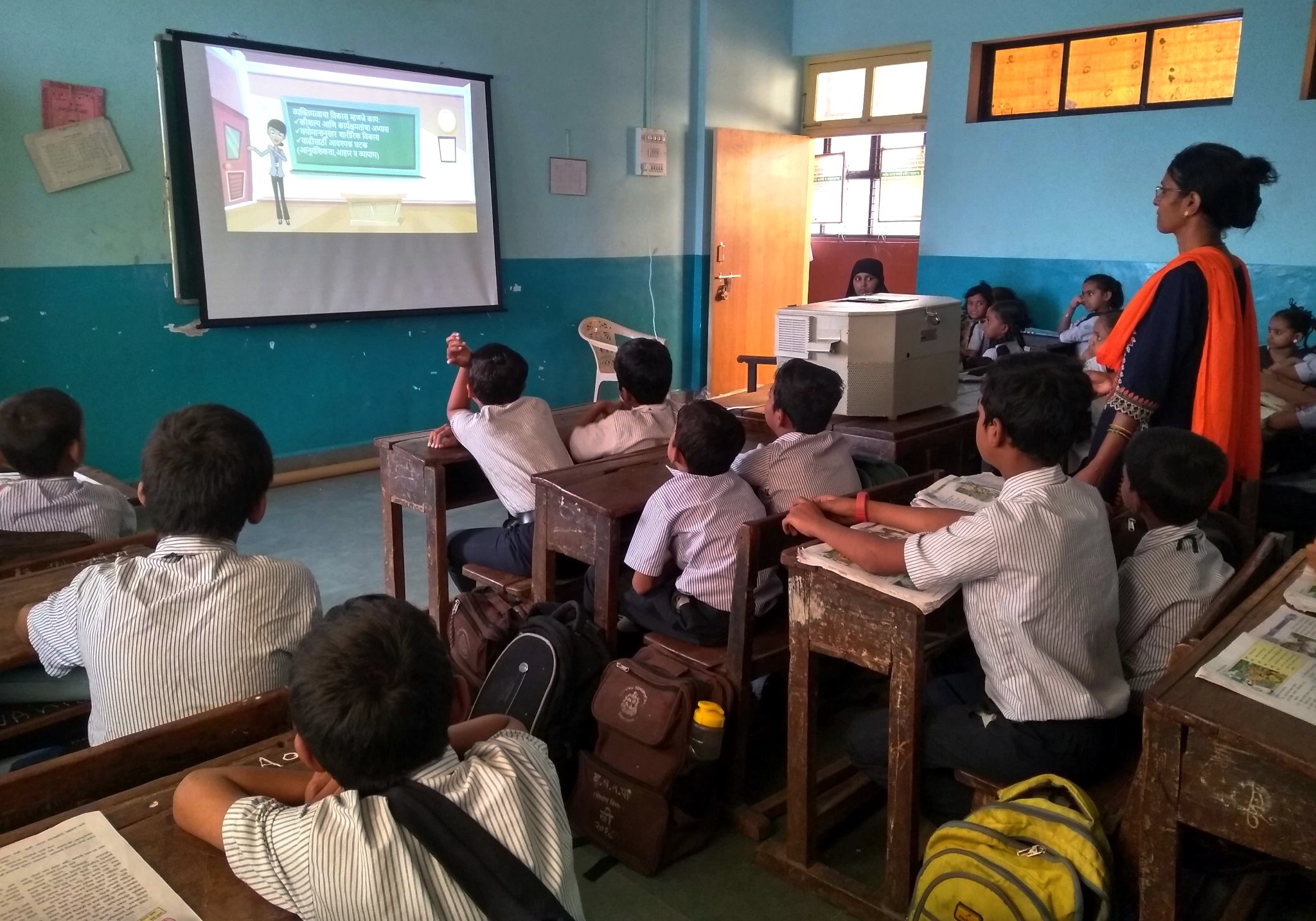 Students watching an interactive lesson on a screen